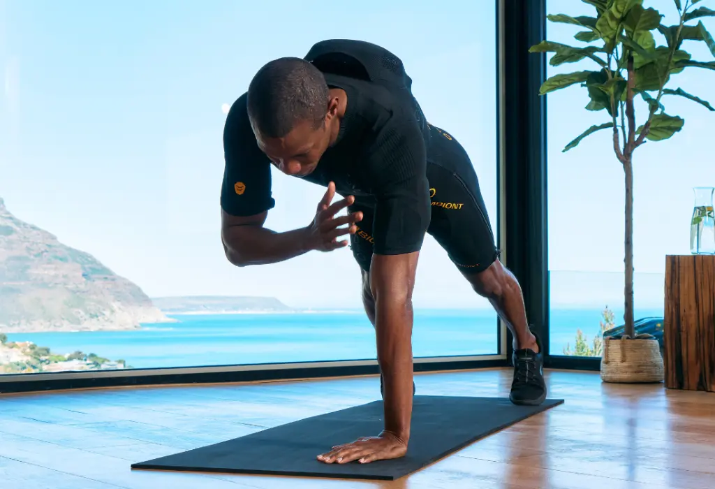 Raggiungere gli obiettivi con l’allenamento EMS a Milano Un uomo in una tuta EMS esegue un esercizio di plank e utilizza l’allenamento EMS a Milano per raggiungere i suoi obiettivi di fitness.