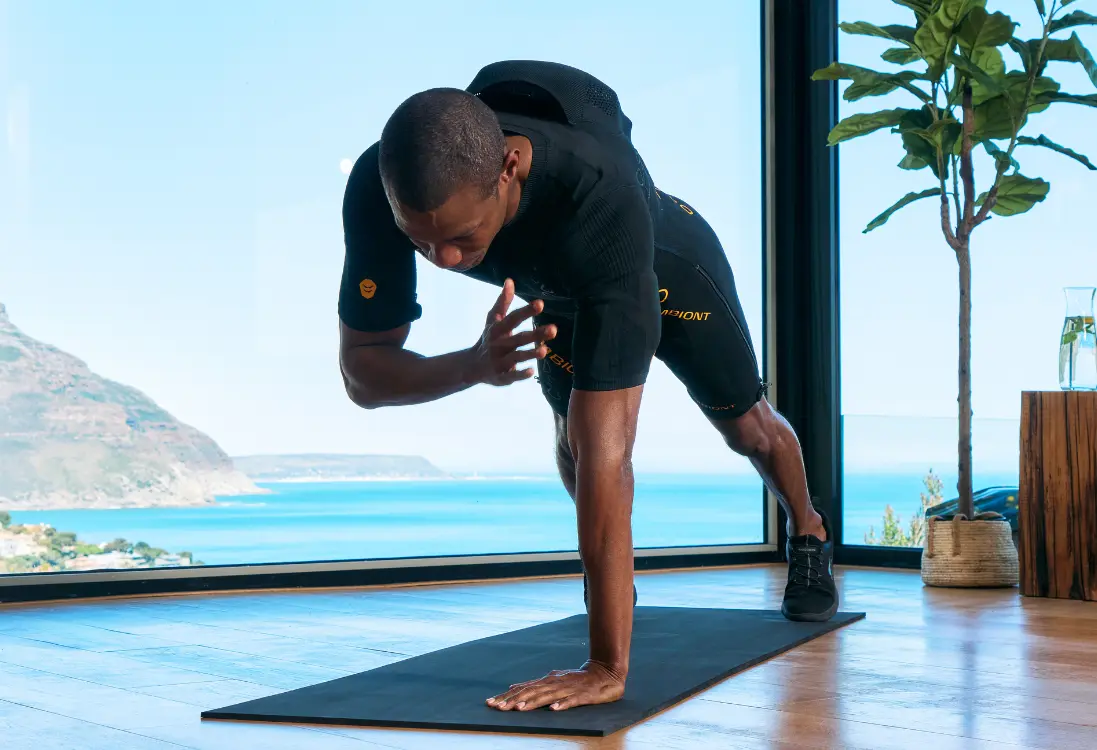Raggiungere gli obiettivi con l’allenamento EMS a Firenze Un uomo in una tuta EMS esegue un esercizio di plank e utilizza l’allenamento EMS a Firenze per raggiungere i suoi obiettivi di fitness.